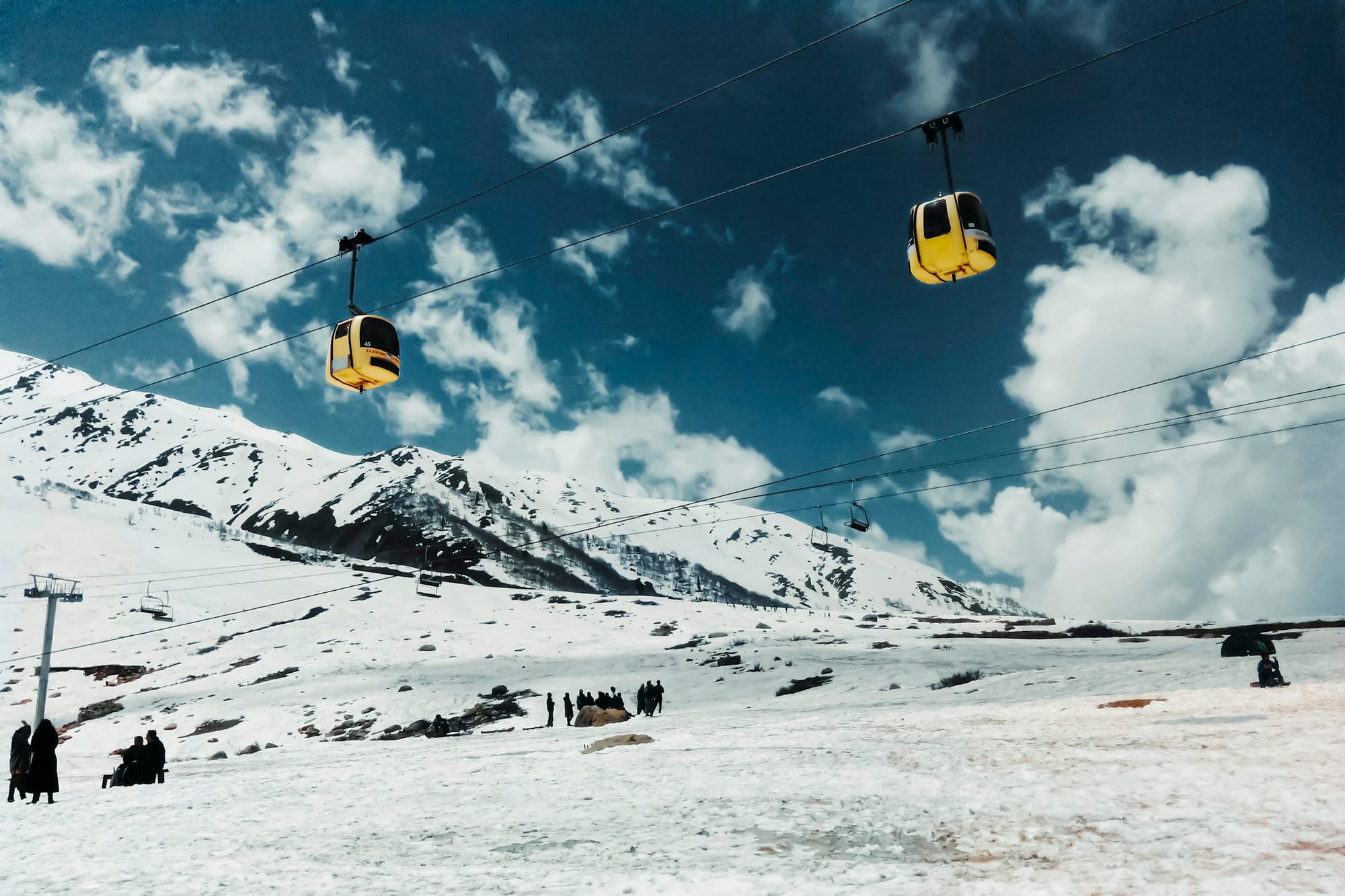 Gulmarg gondola cabins over snowfields and white mountains on a clear winter day